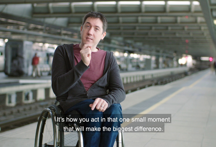 A man sat in a wheelchair at a train station